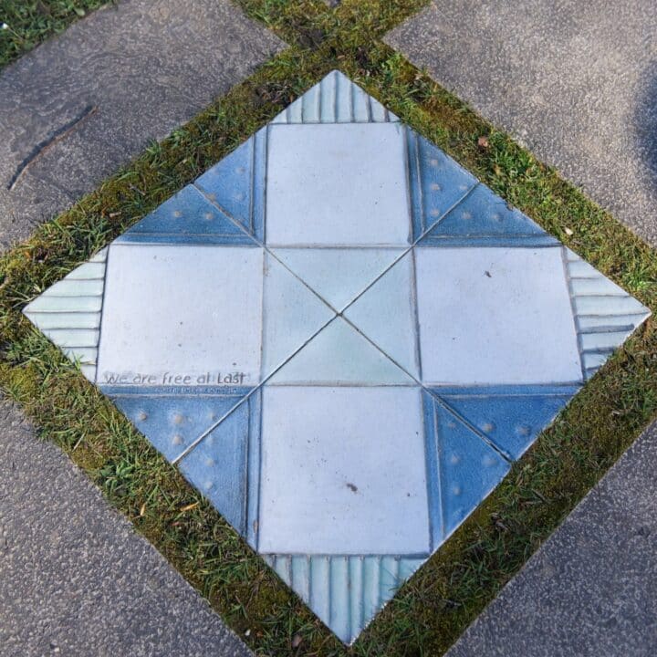A tile on the ground with a design reading "We are free at last"